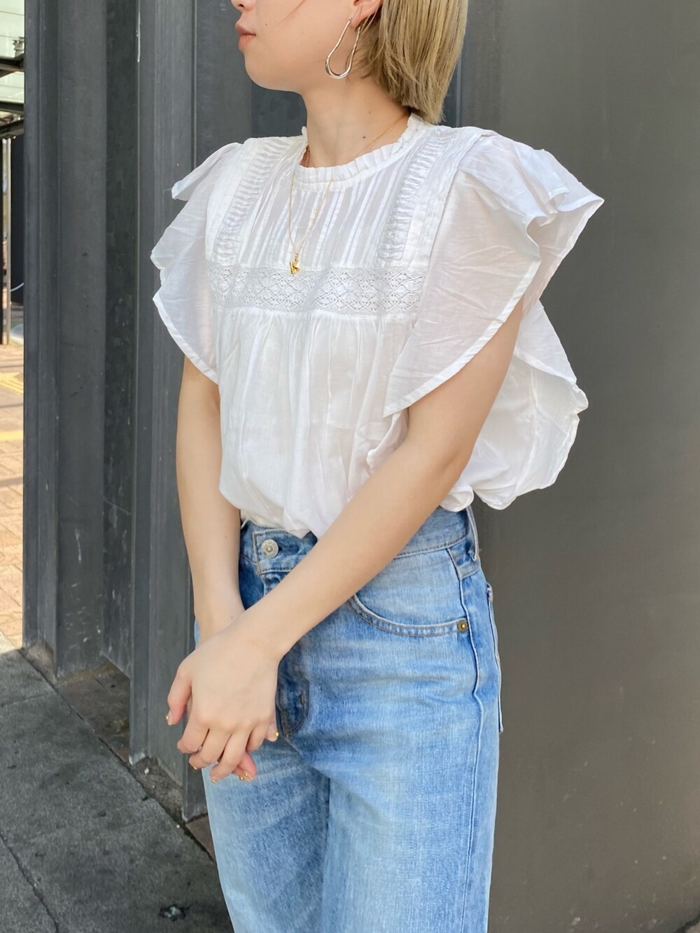 ホワイト系のシャツ/ブラウス、ブルー系のデニムパンツ、ゴールド系のネックレスを着用したレディースの春コーディネートの3枚目の写真