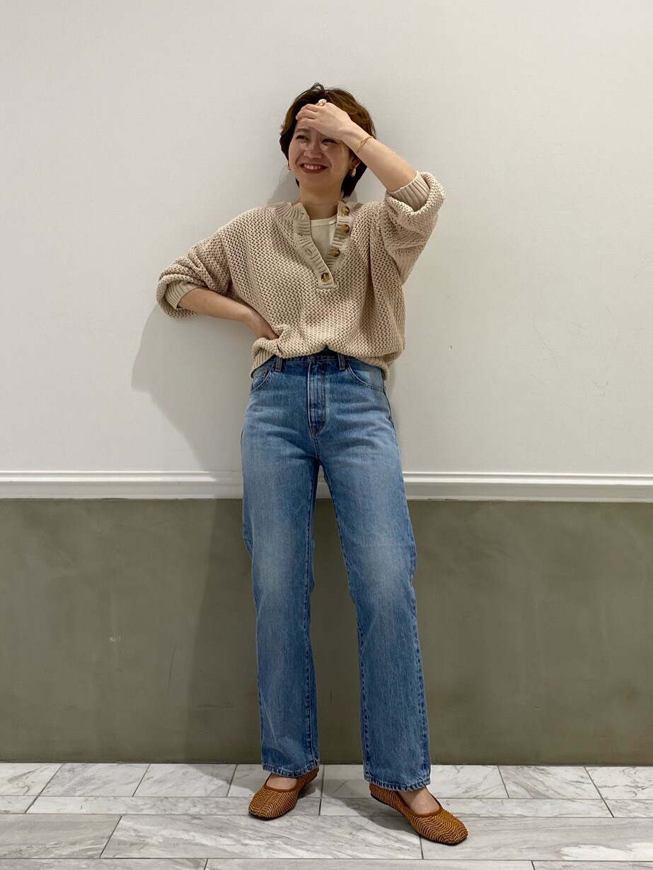 ブルー系のデニムパンツ、ホワイト系のニット/セーター、ホワイト系のタンクトップを着用したレディースの春コーディネートの2枚目の写真