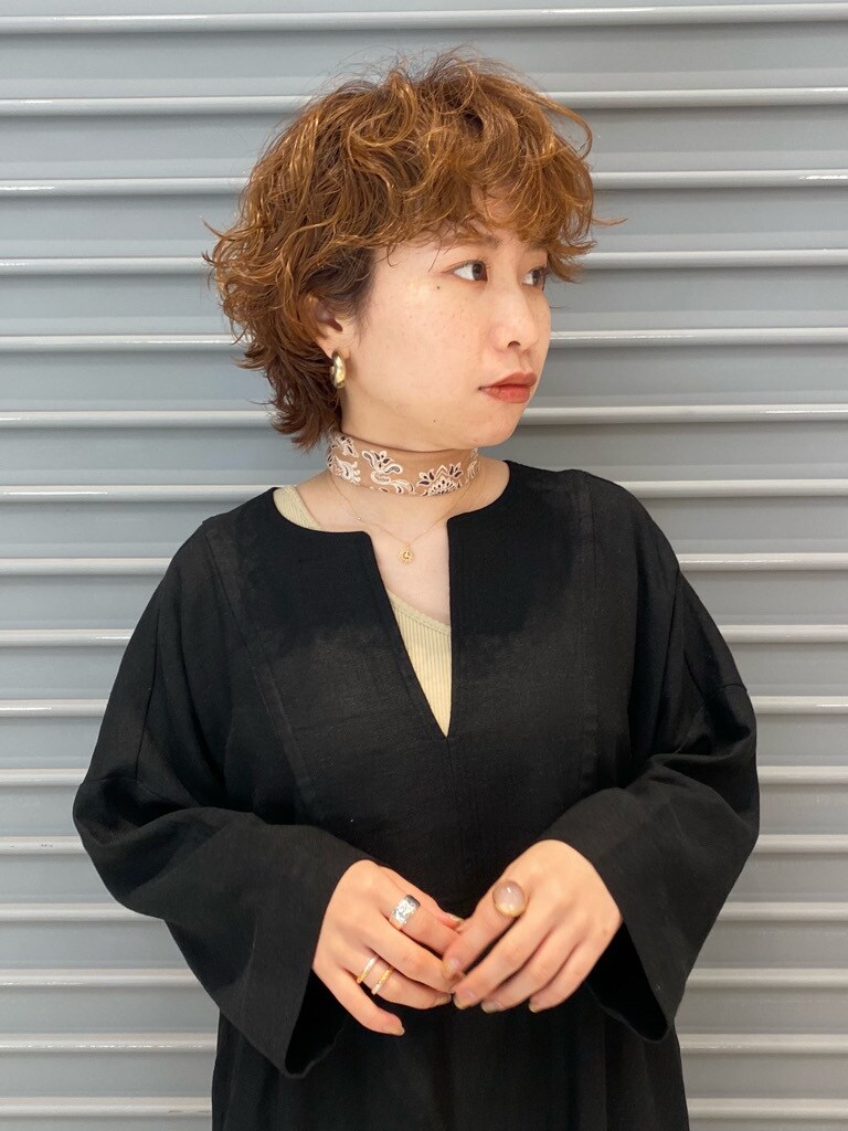 ベージュ系のタンクトップ、ブラック系のワンピースを着用したレディースの春コーディネートの3枚目の写真