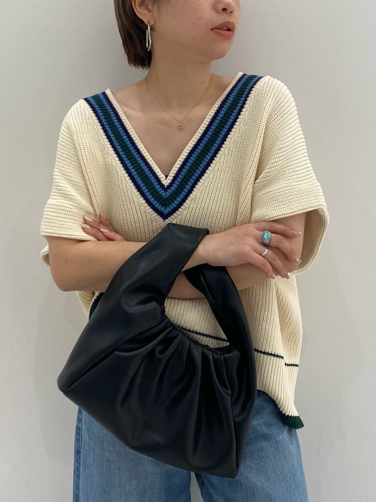 ベージュ系のトレンチコート、ゴールド系のパンプス、ブルー系のデニムパンツを着用したレディースの秋コーディネートの3枚目の写真