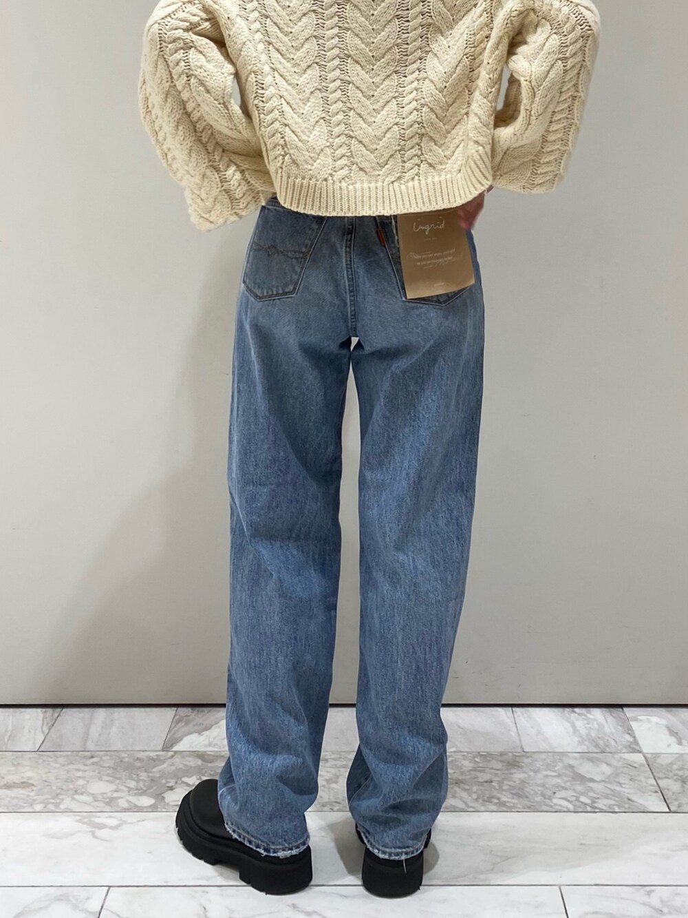 ブルー系のデニムパンツ、ホワイト系のニット/セーター、レッド系のニット/セーターを着用したレディースの冬コーディネートの5枚目の写真