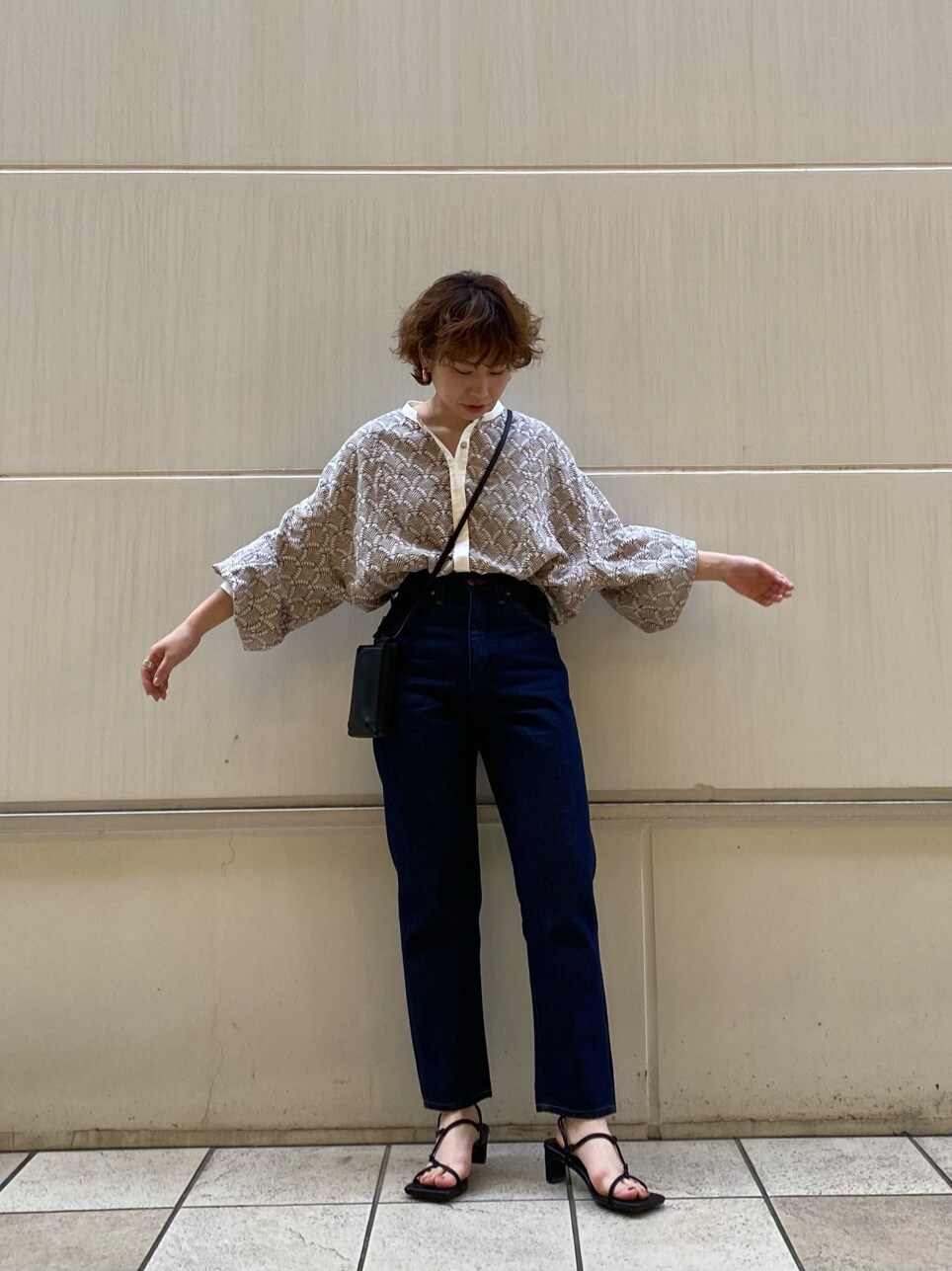 ブルー系のデニムパンツ、ブラック系のサンダルを着用したレディースの春コーディネートの3枚目の写真