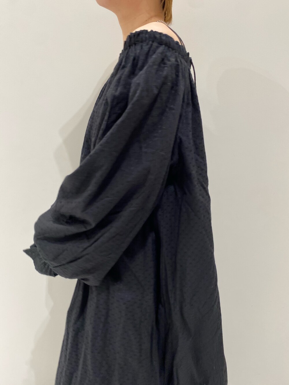 ブラック系のワンピース、オレンジ系のキャップを着用したレディースの春コーディネートの7枚目の写真