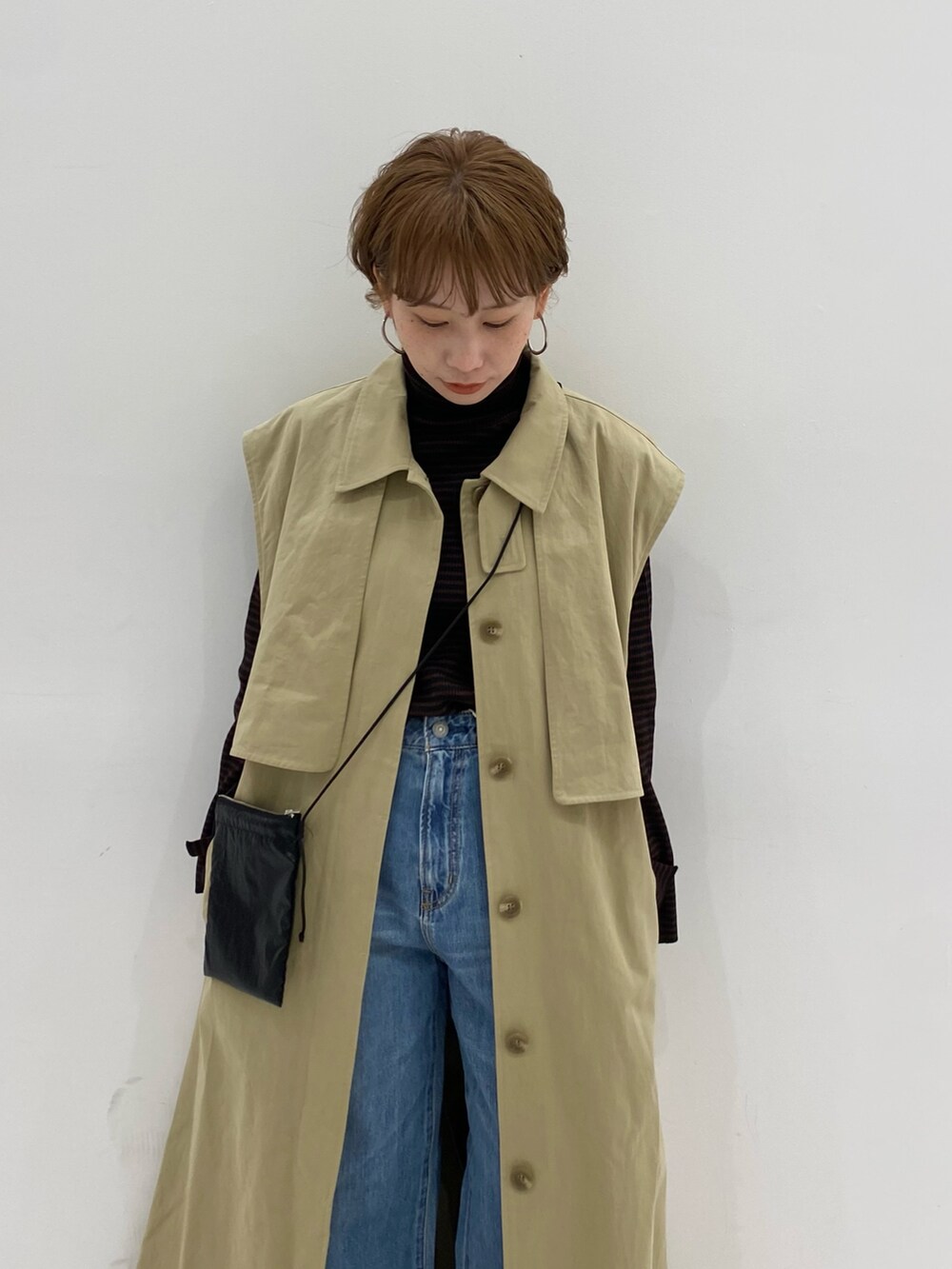 ベージュ系のその他アウター、ブラック系のショルダーバッグ、ブラウン系のニット/セーターを着用したレディースの冬コーディネートの3枚目の写真