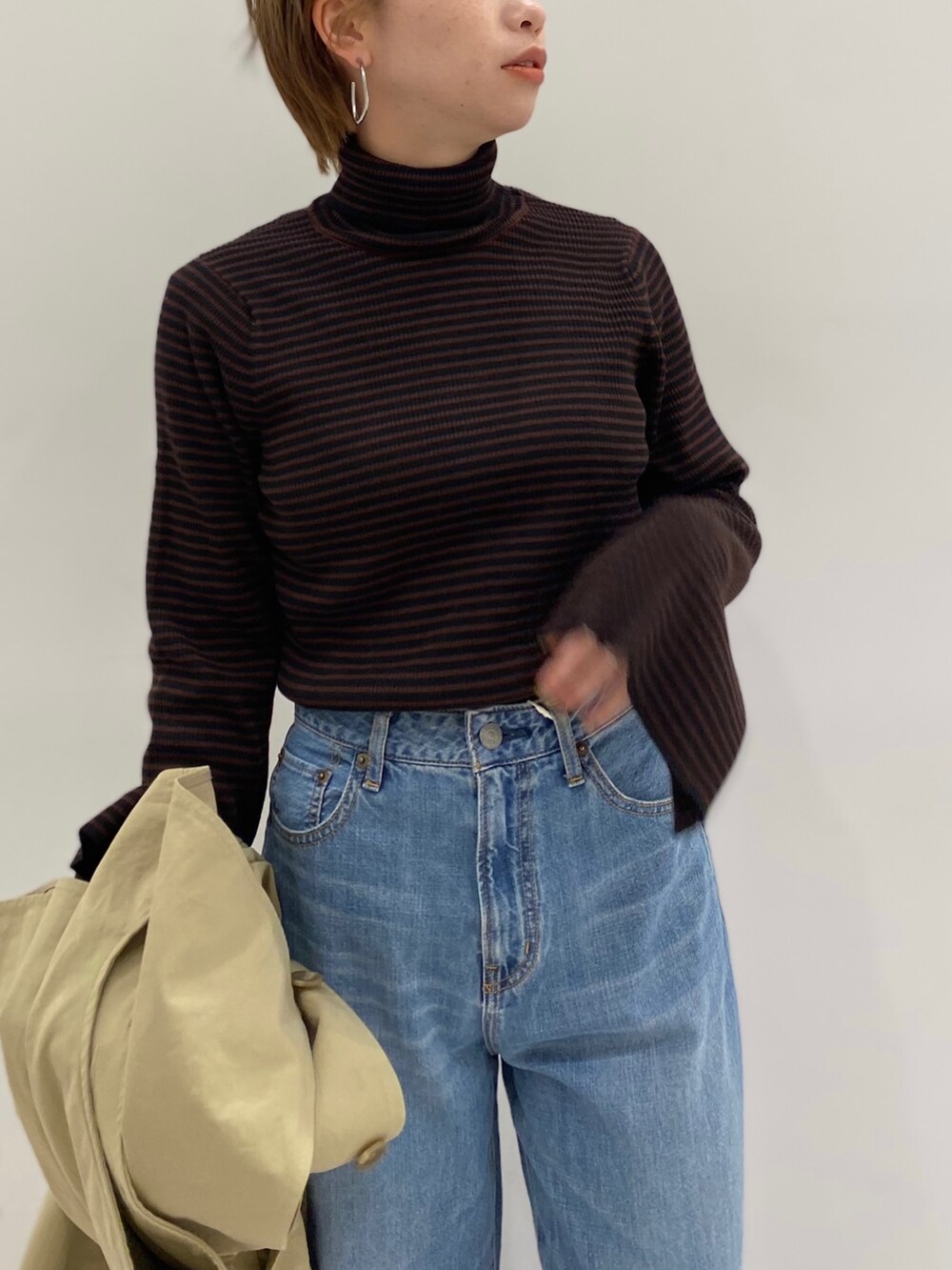 ベージュ系のその他アウター、ブラック系のショルダーバッグ、ブラウン系のニット/セーターを着用したレディースの冬コーディネートの5枚目の写真