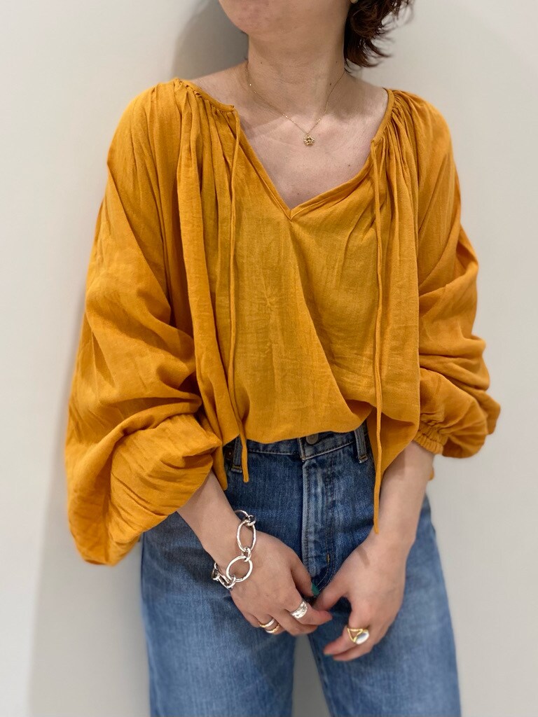 ブルー系のデニムパンツ、オレンジ系のシャツ/ブラウス、ブラック系のサンダルを着用したレディースの春コーディネートの4枚目の写真