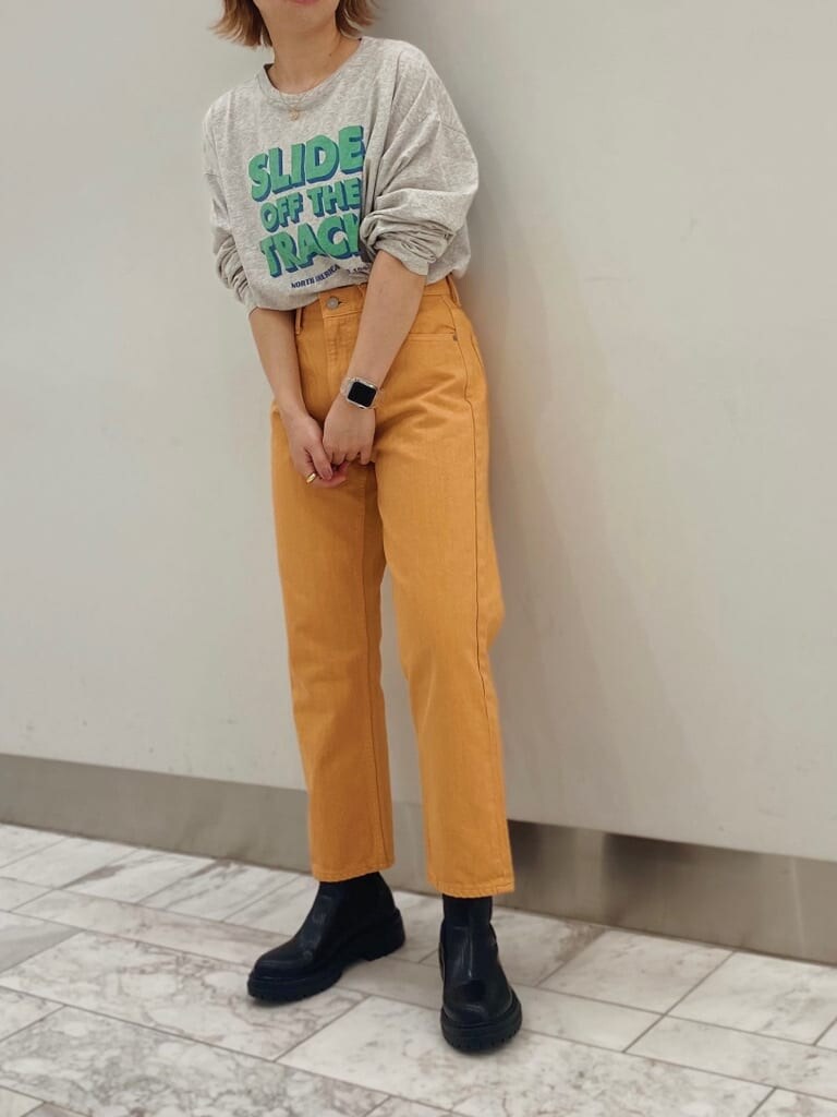 グレー系のTシャツ/カットソー、オレンジ系のデニムパンツを着用したレディースの春コーディネートの3枚目の写真