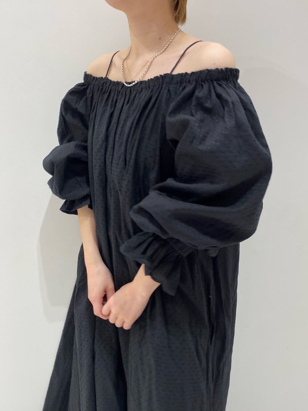 ブラック系のワンピース、オレンジ系のキャップを着用したレディースの春コーディネートの6枚目の写真