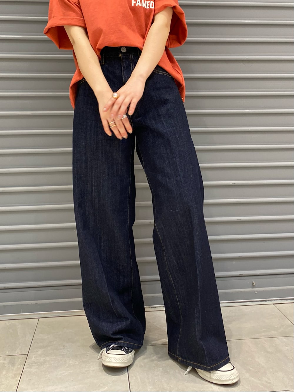 ブルー系のデニムパンツ、オレンジ系のTシャツ/カットソーを着用したレディースの春コーディネートの6枚目の写真