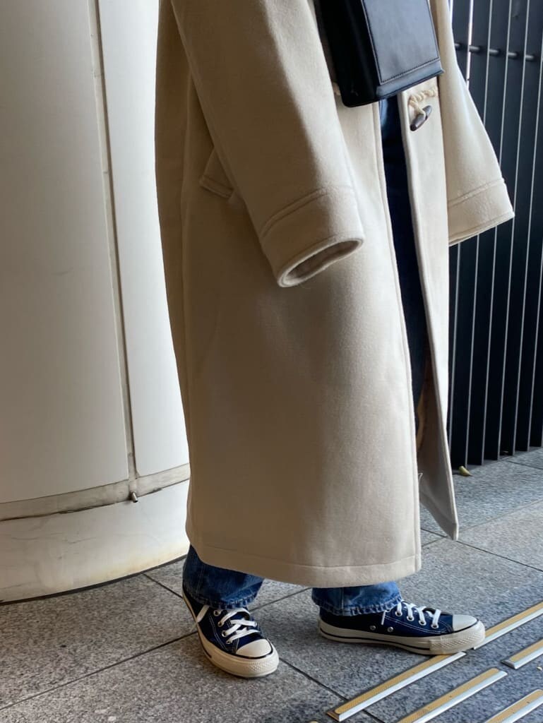 ブルー系のデニムパンツ、ブルー系のスニーカー、ホワイト系のダッフルコートを着用したレディースの冬コーディネートの6枚目の写真