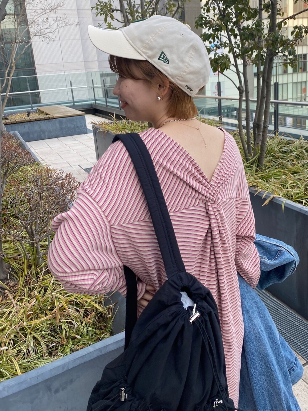 ピンク系のワンピース、ブルー系のデニムジャケット、ブラック系のバックパック/リュックを着用したレディースの冬コーディネートの5枚目の写真