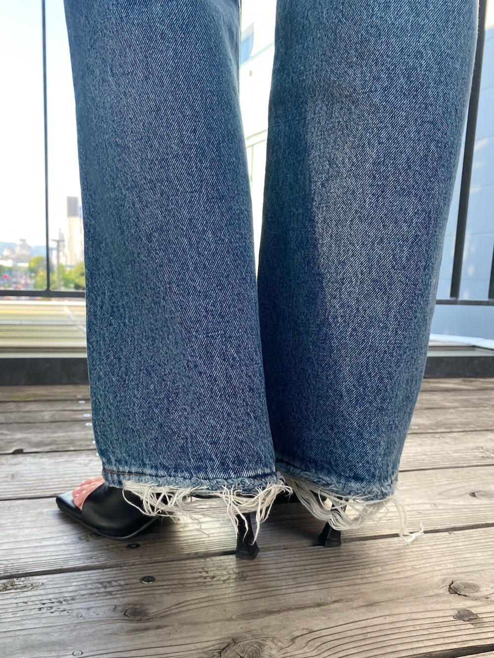 ブルー系のデニムパンツ、ホワイト系のシャツ/ブラウスを着用したレディースの夏コーディネートの5枚目の写真