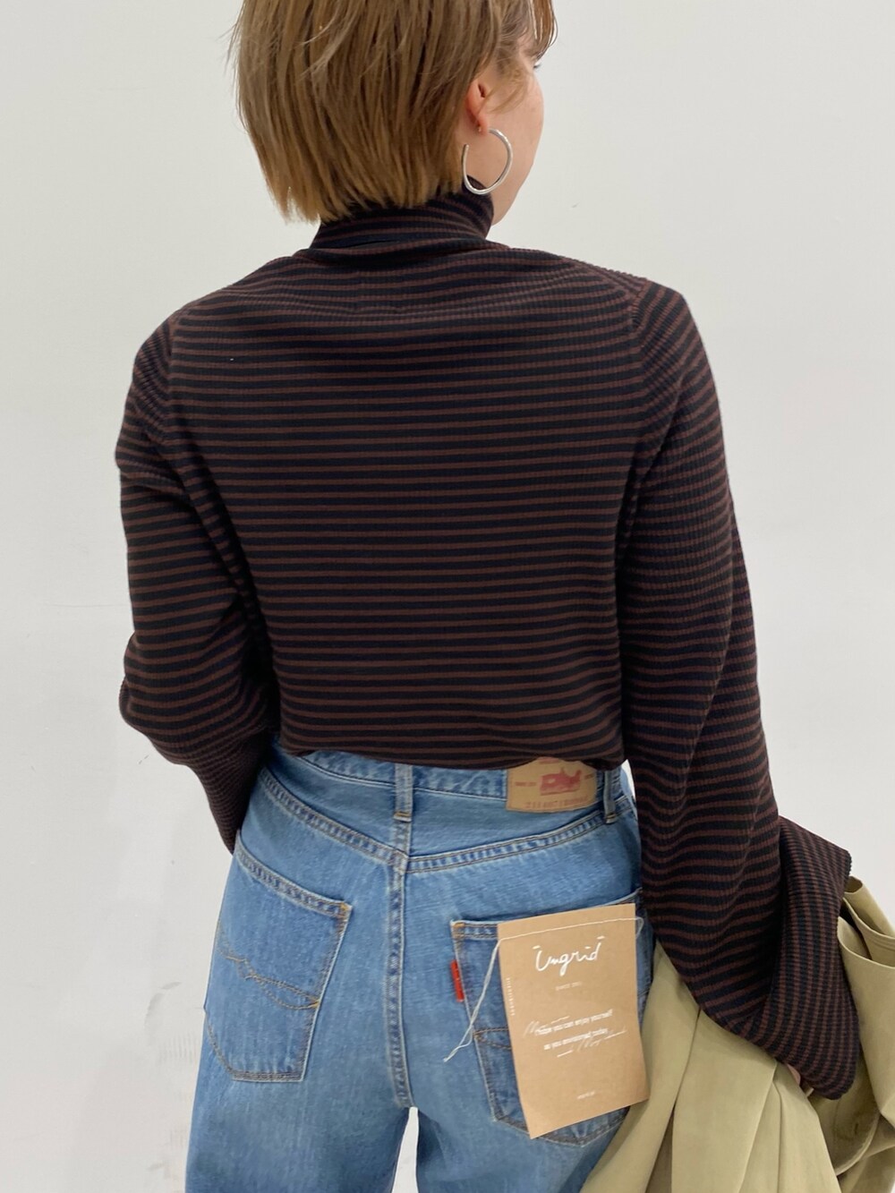 ベージュ系のその他アウター、ブラック系のショルダーバッグ、ブラウン系のニット/セーターを着用したレディースの冬コーディネートの6枚目の写真