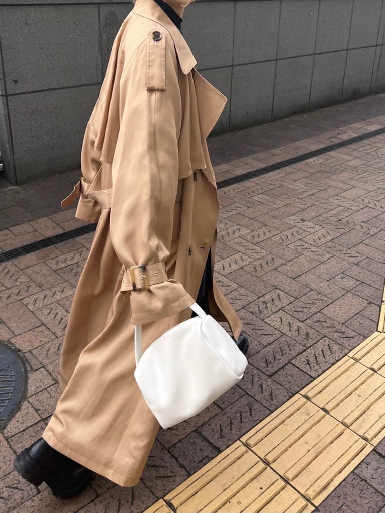 ベージュ系のトレンチコート、ブラック系のシャツ/ブラウス、ホワイト系のハンドバッグを着用したレディースの冬コーディネートの9枚目の写真
