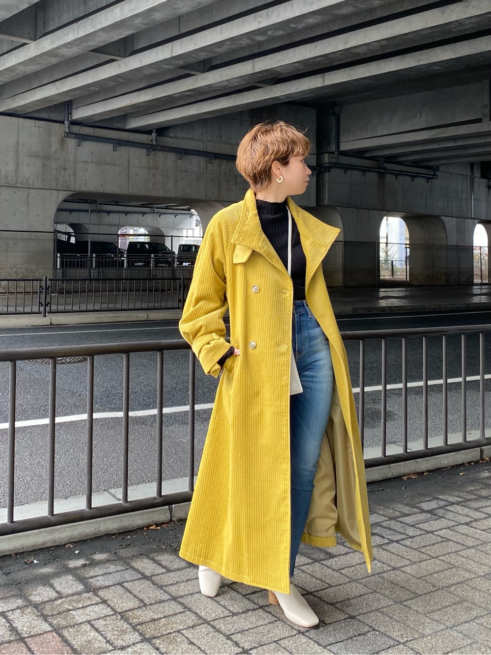 ブラック系のニット/セーター、グリーン系のその他アウター、ブルー系のデニムパンツを着用したレディースの冬コーディネートの4枚目の写真