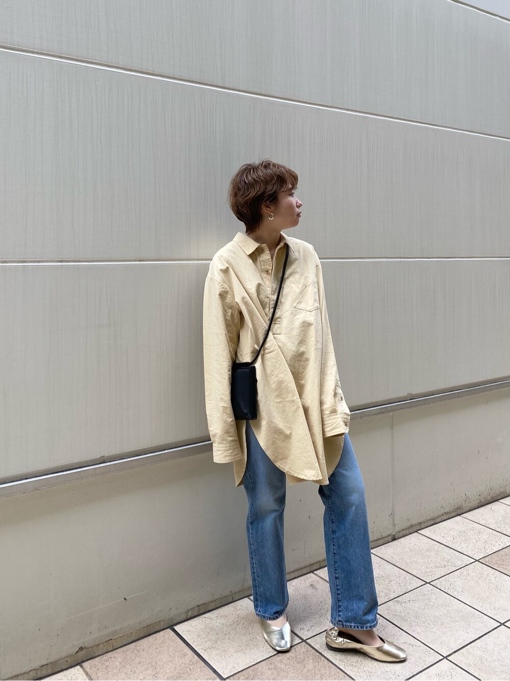 ゴールド系のバレエシューズ、イエロー系のシャツ/ブラウス、ブラック系のボディバッグ/ウエストポーチを着用したレディースの冬コーディネートの4枚目の写真