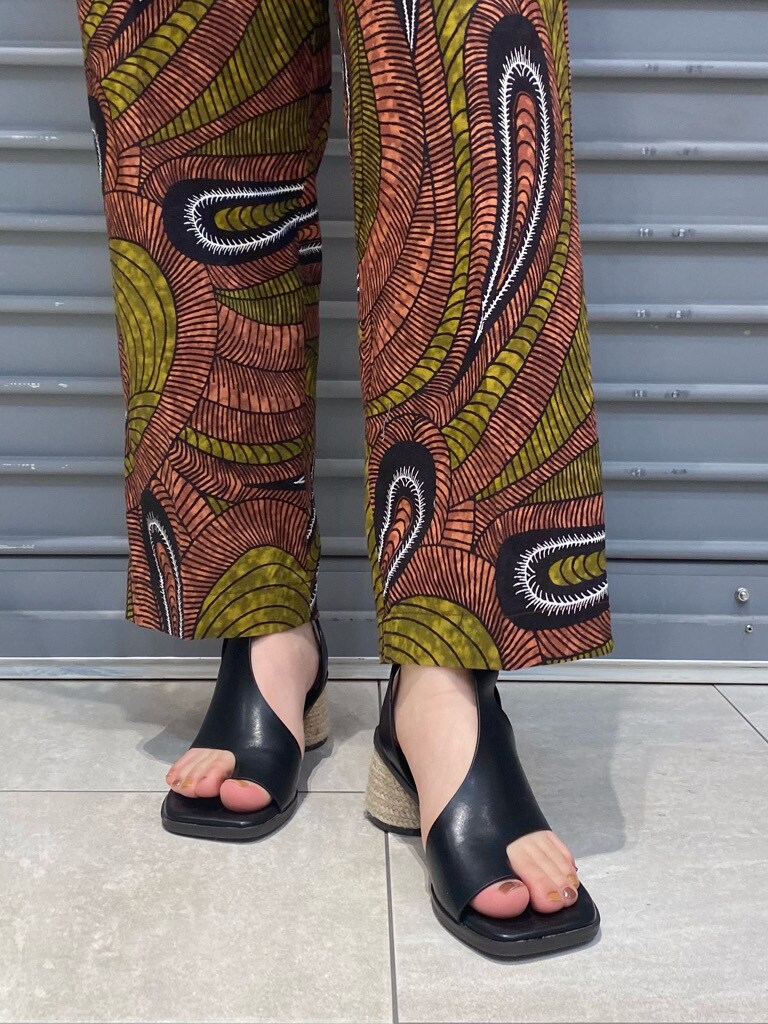 グリーン系のその他パンツ、ベージュ系のかごバッグ、ブラック系のサンダルを着用したレディースの春コーディネートの6枚目の写真
