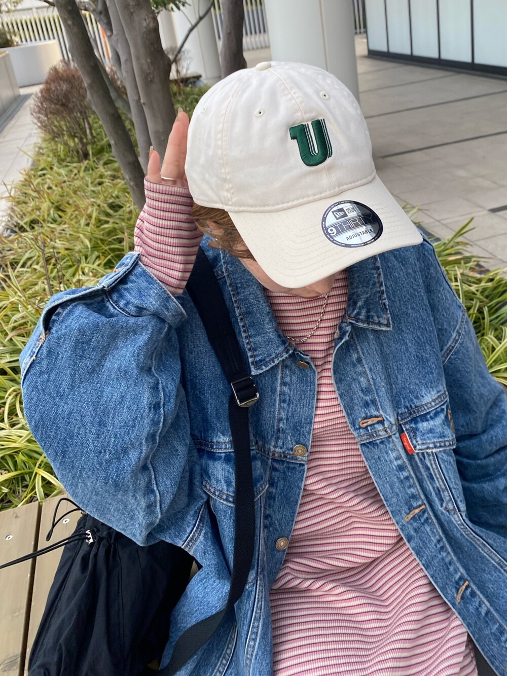 ピンク系のワンピース、ブルー系のデニムジャケット、ブラック系のバックパック/リュックを着用したレディースの冬コーディネートの6枚目の写真