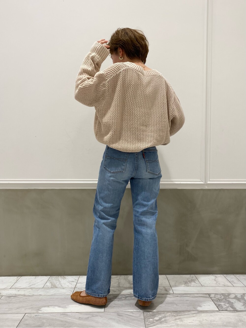 ブルー系のデニムパンツ、ホワイト系のニット/セーター、ホワイト系のタンクトップを着用したレディースの春コーディネートの3枚目の写真