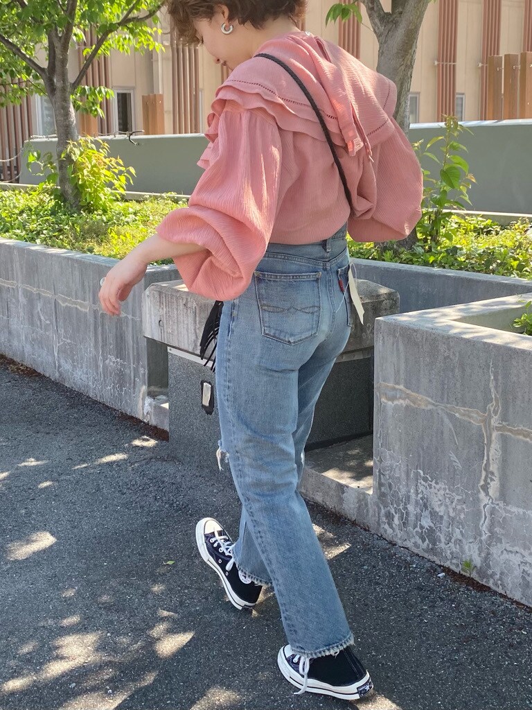 ブラック系のハンドバッグ、ブルー系のデニムパンツ、ピンク系のシャツ/ブラウスを着用したレディースの春コーディネートの7枚目の写真