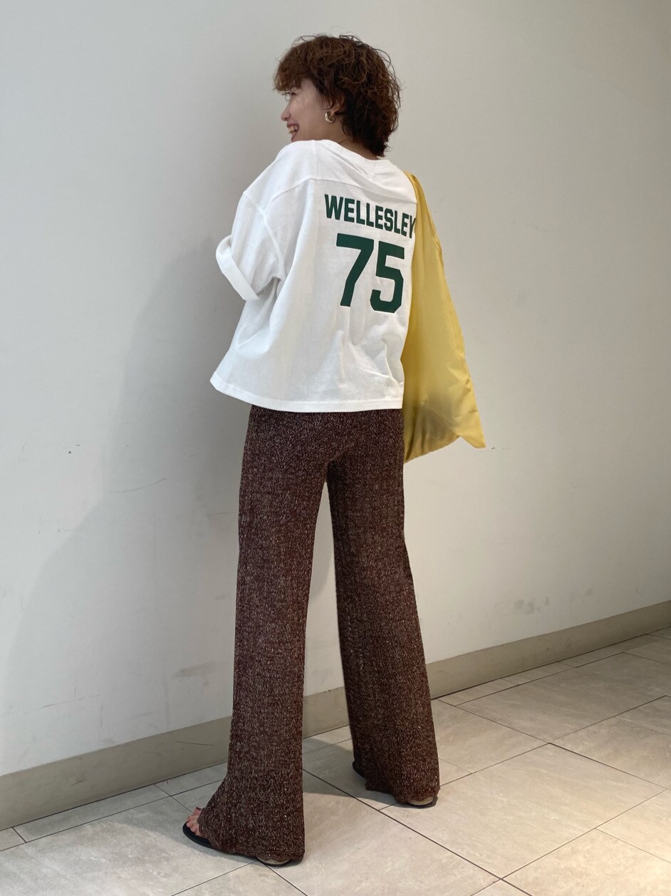 ブラック系のサンダル、イエロー系のハンドバッグ、ホワイト系のTシャツ/カットソーを着用したレディースの春コーディネートの2枚目の写真