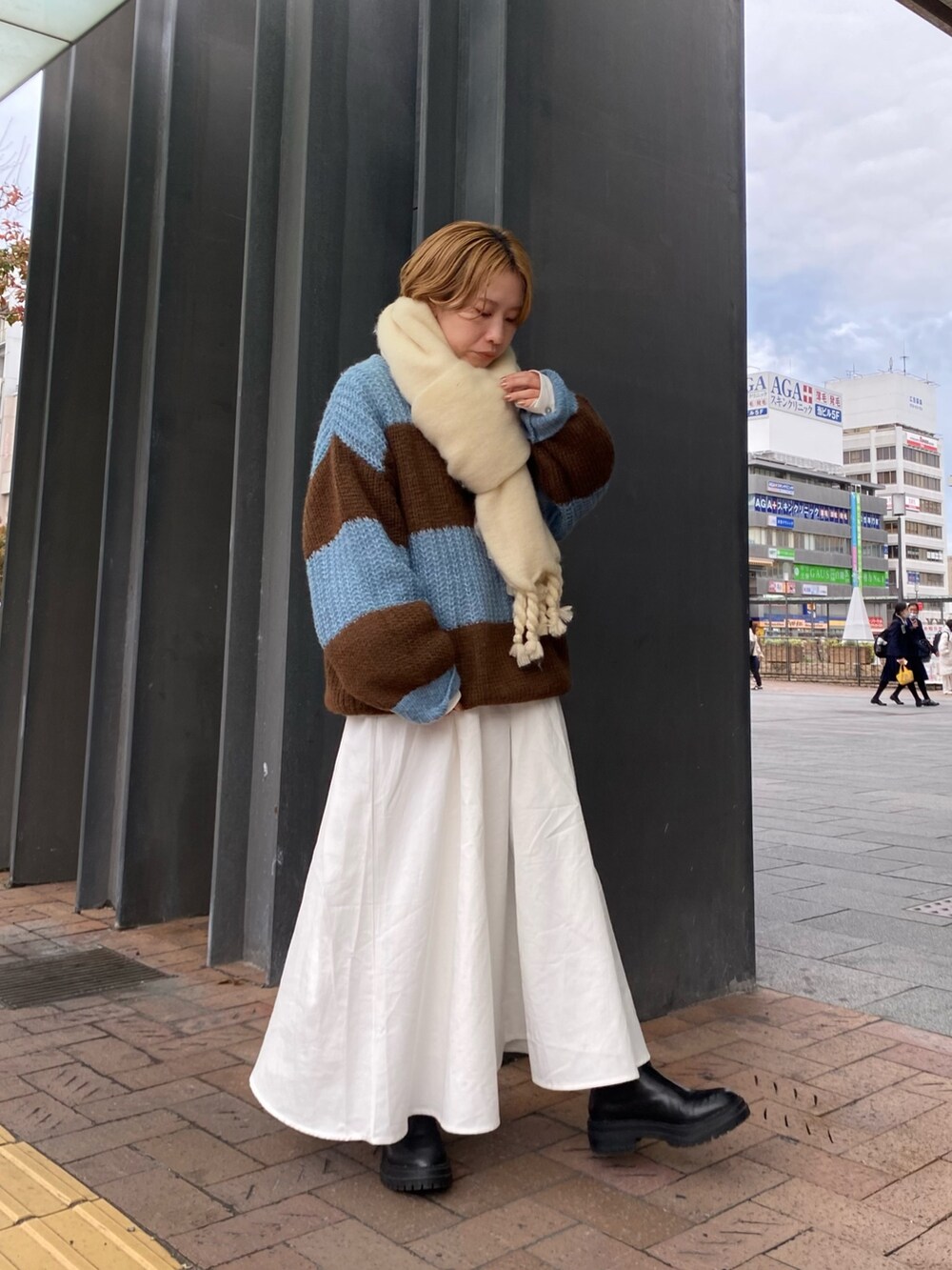ブルー系のニット/セーター、ブラック系のワンピース、ホワイト系のマフラーを着用したレディースの秋コーディネートの3枚目の写真