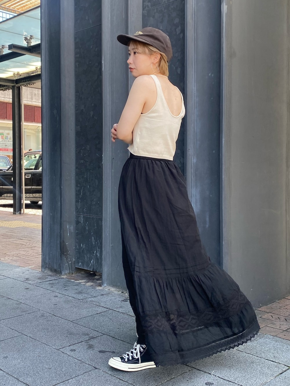 ホワイト系のベスト、ブラック系のスカートを着用したレディースの夏コーディネートの2枚目の写真