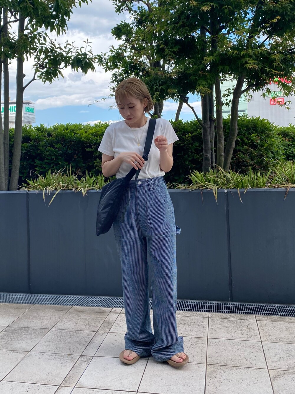 ホワイト系のTシャツ/カットソー、その他のデニムパンツ、ブラック系のハンドバッグを着用したレディースの春コーディネートの5枚目の写真