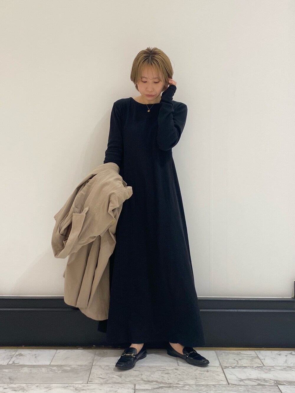 ベージュ系のステンカラーコートを着用したレディースの春コーディネートの4枚目の写真
