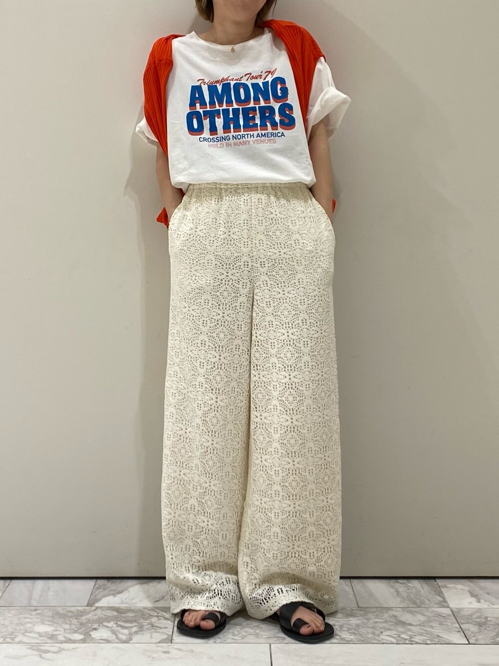 ホワイト系のTシャツ/カットソー、オレンジ系のカーディガン/ボレロ、ホワイト系のその他パンツを着用したレディースの春コーディネートの4枚目の写真