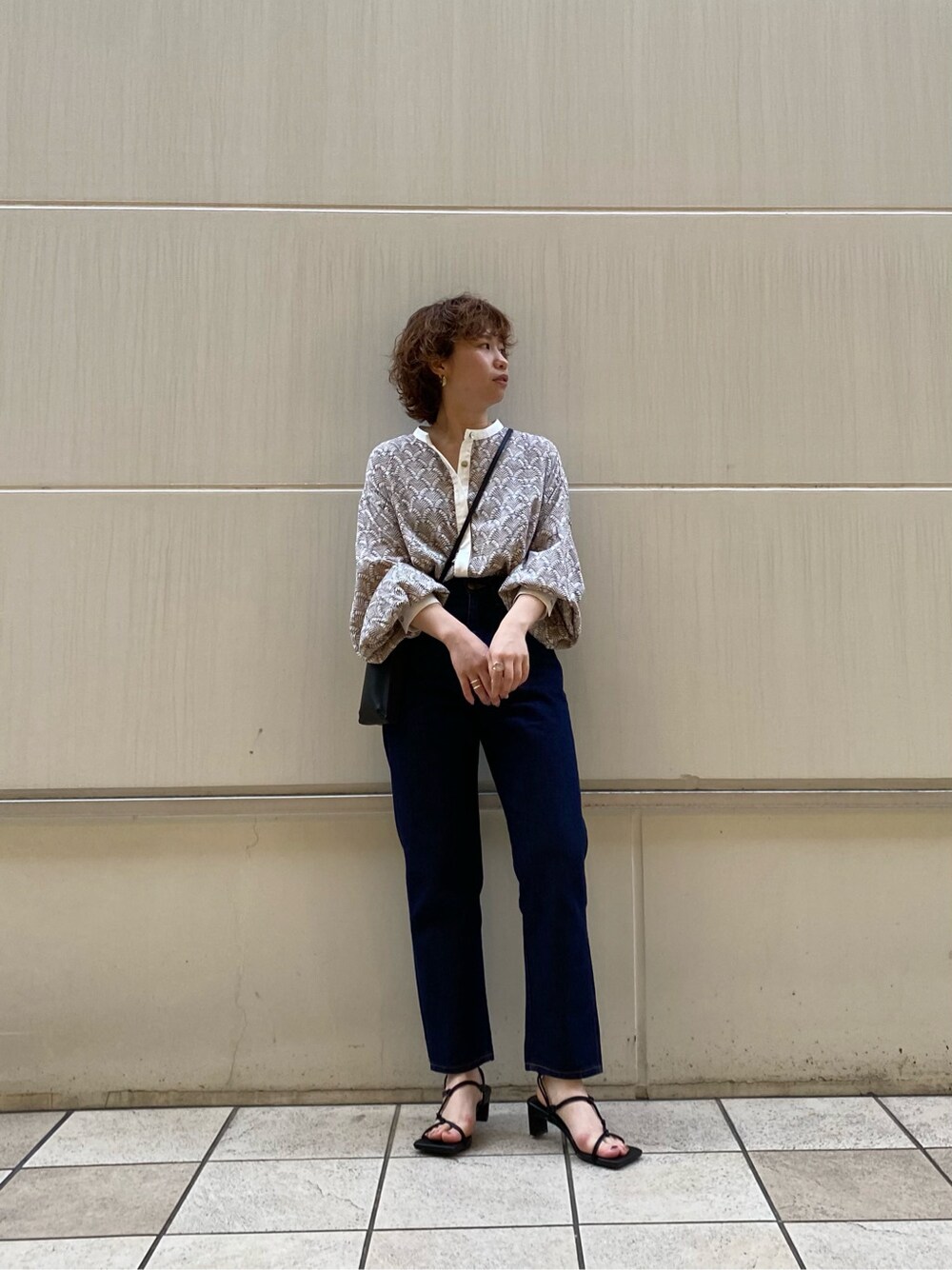 ブルー系のデニムパンツ、ブラック系のサンダルを着用したレディースの春コーディネートの2枚目の写真