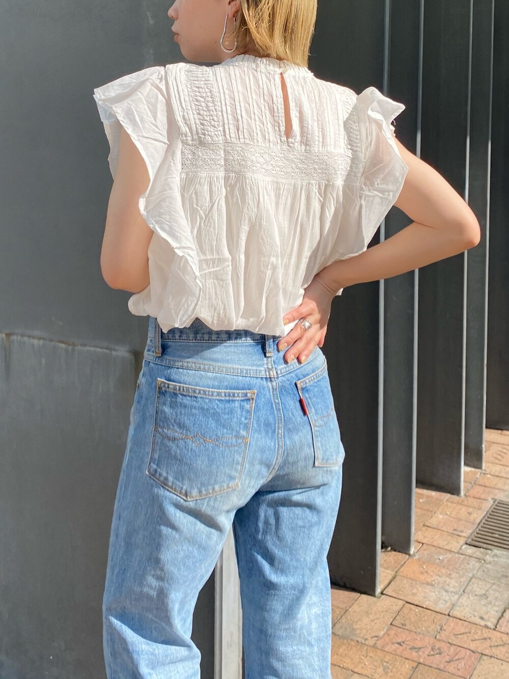 ホワイト系のシャツ/ブラウス、ブルー系のデニムパンツ、ゴールド系のネックレスを着用したレディースの春コーディネートの4枚目の写真