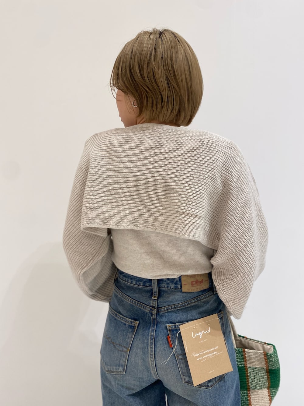 ブルー系のデニムパンツ、ホワイト系のニット/セーターを着用したレディースの春コーディネートの4枚目の写真