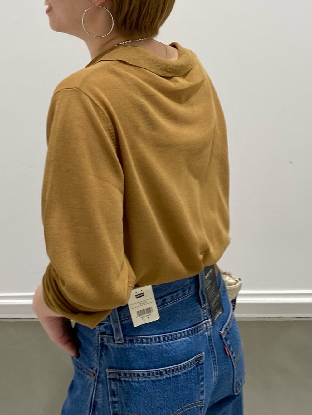 イエロー系のカーディガン/ボレロ、ホワイト系のハンドバッグを着用したレディースの春コーディネートの4枚目の写真