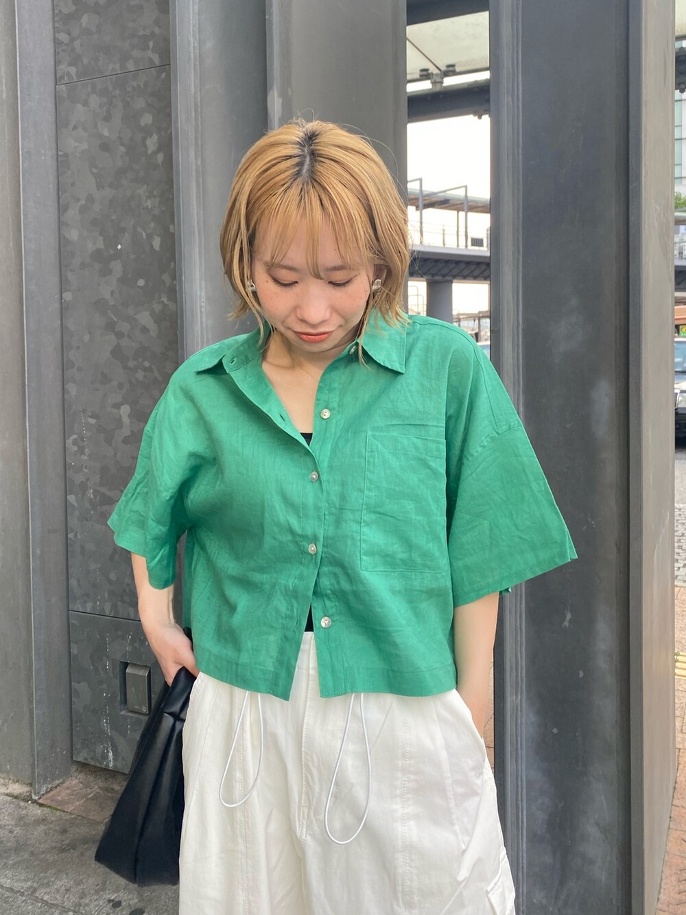 グリーン系のシャツ/ブラウス、ホワイト系のカーゴパンツ、ブラック系のハンドバッグを着用したレディースの夏コーディネートの4枚目の写真