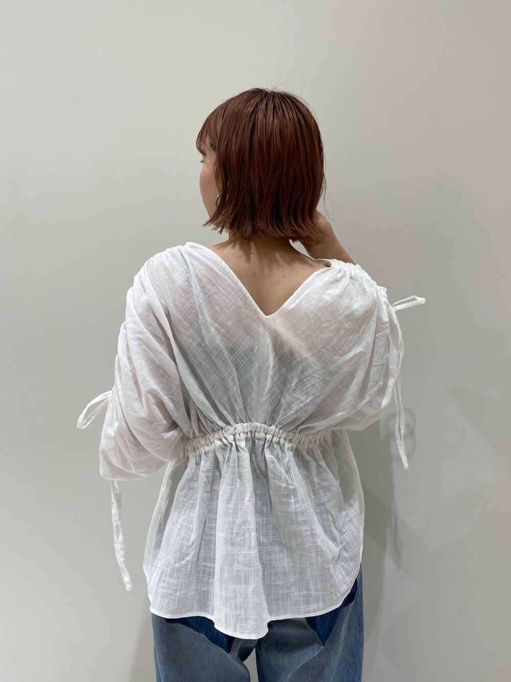 ホワイト系のシャツ/ブラウス、オレンジ系のトートバッグ、ブルー系のデニムパンツを着用したレディースの夏コーディネートの3枚目の写真