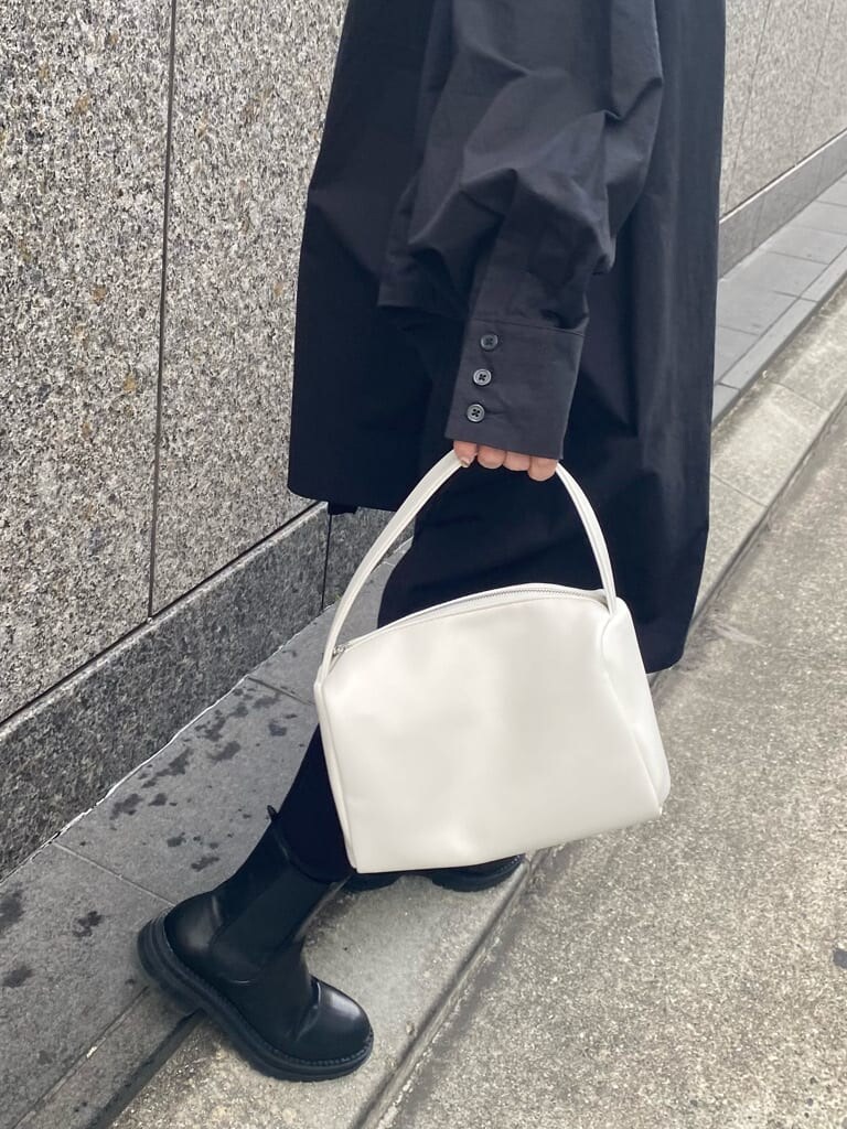 ベージュ系のトレンチコート、ブラック系のシャツ/ブラウス、ホワイト系のハンドバッグを着用したレディースの冬コーディネートの6枚目の写真