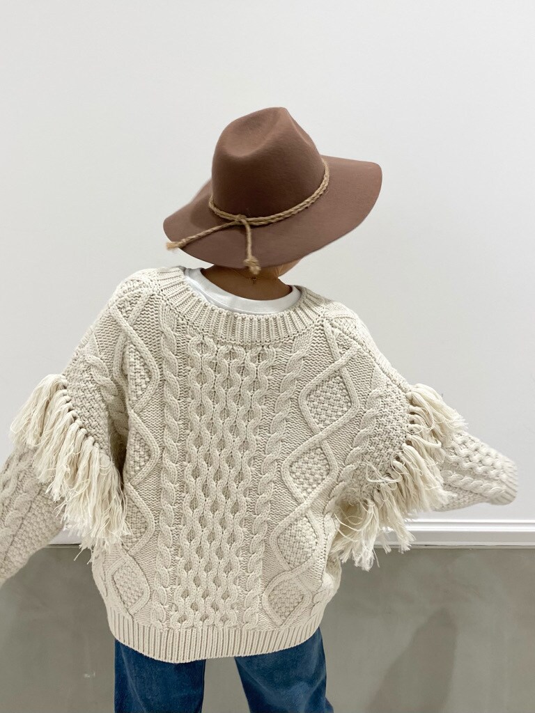 ブルー系のデニムパンツ、ホワイト系のニット/セーター、ホワイト系のTシャツ/カットソーを着用したレディースの冬コーディネートの6枚目の写真