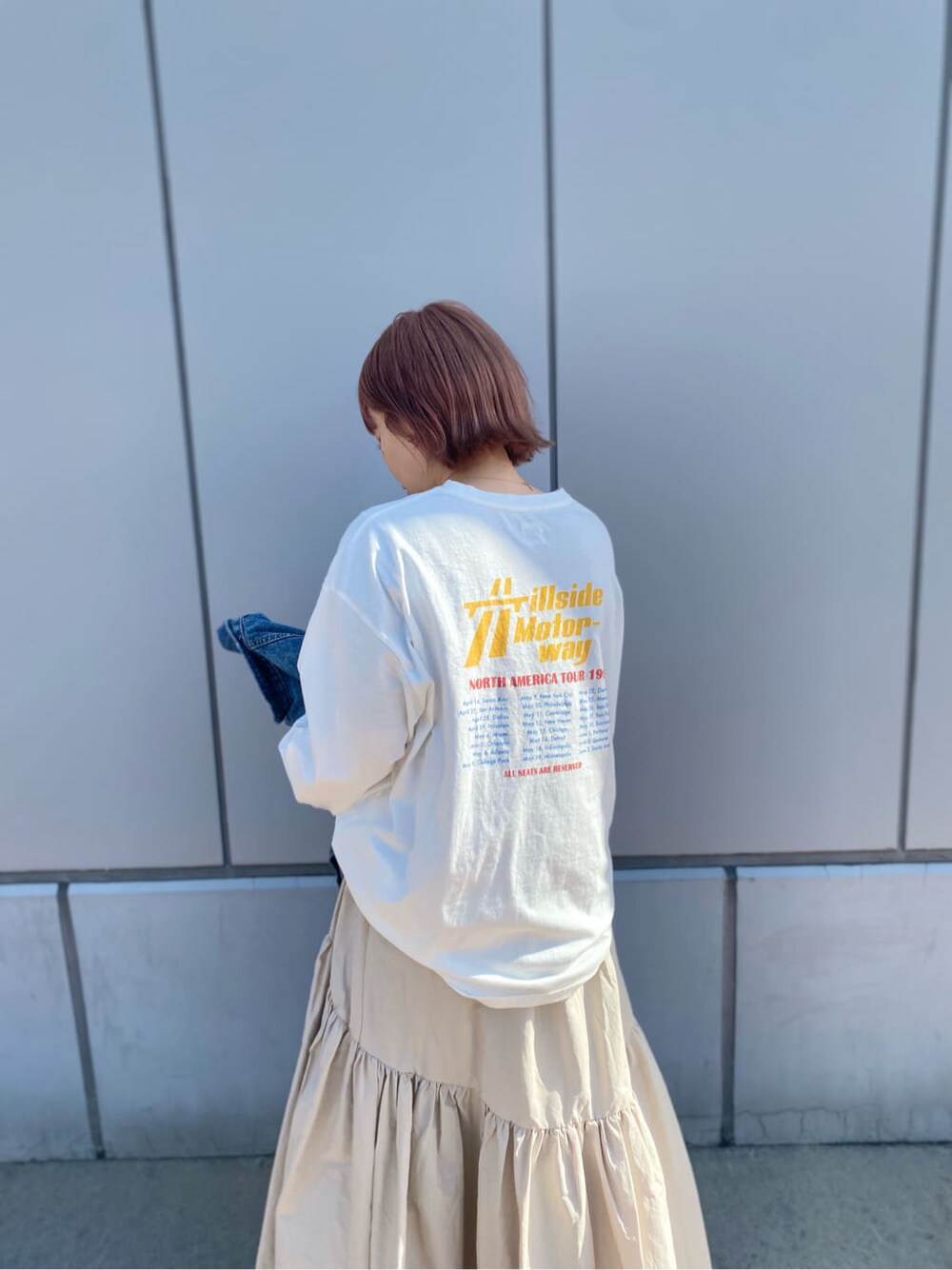 ホワイト系のスカート、ホワイト系のTシャツ/カットソー、ブルー系のデニムジャケットを着用したレディースの冬コーディネートの3枚目の写真
