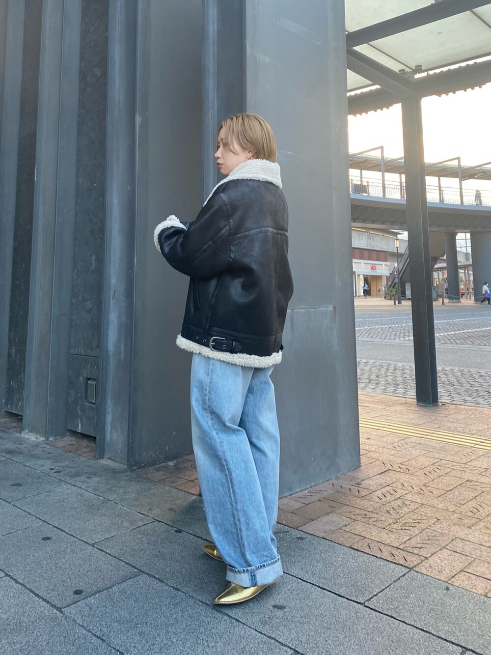 ピンク系のニット/セーター、ブルー系のデニムパンツ、ブラック系のクラッチバッグを着用したレディースの秋コーディネートの6枚目の写真