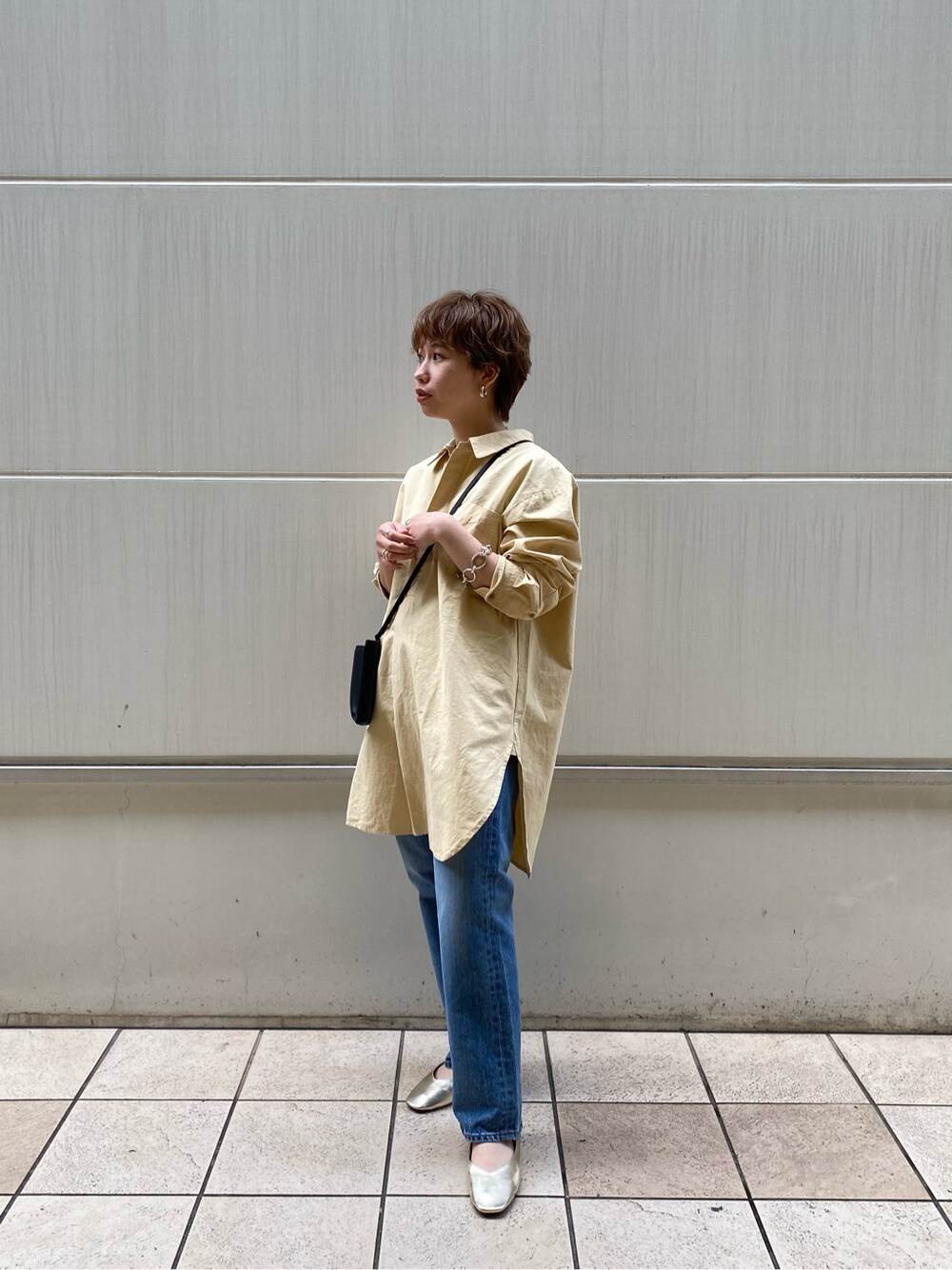 ゴールド系のバレエシューズ、イエロー系のシャツ/ブラウス、ブラック系のボディバッグ/ウエストポーチを着用したレディースの冬コーディネートの7枚目の写真