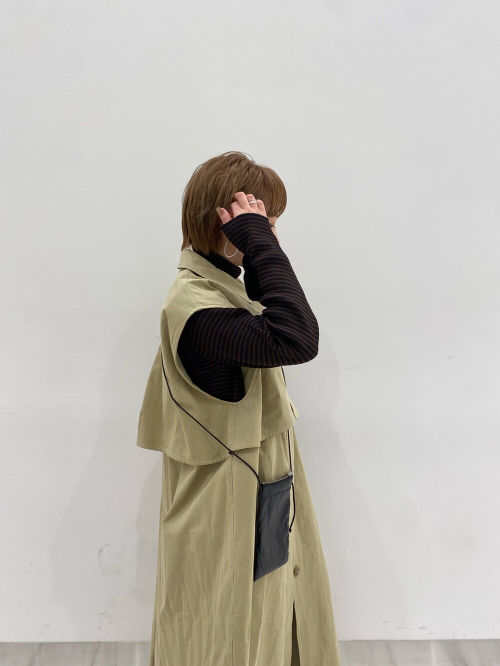 ベージュ系のその他アウター、ブラック系のショルダーバッグ、ブラウン系のニット/セーターを着用したレディースの冬コーディネートの4枚目の写真