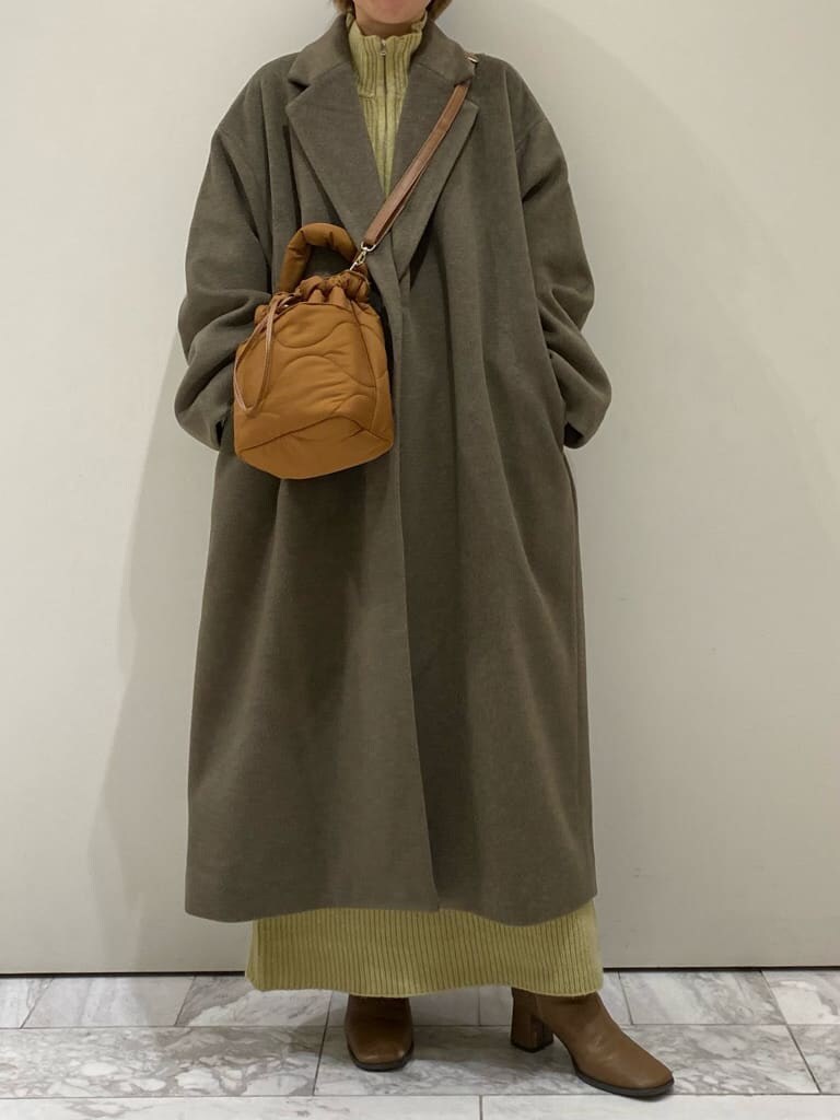 ブラック系のTシャツ/カットソー、ブラウン系のチェスターコート、グリーン系のワンピースを着用したレディースの冬コーディネートの5枚目の写真