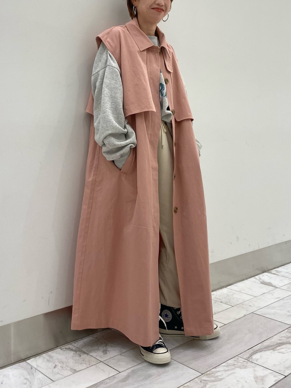 グレー系のスウェット、ピンク系のその他アウターを着用したレディースの冬コーディネートの2枚目の写真