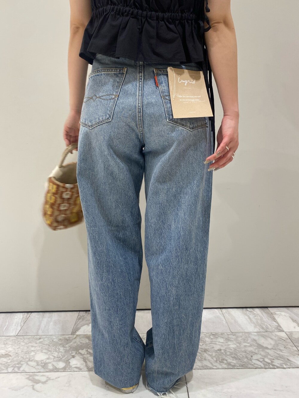 ブラック系のワンピース、ホワイト系のTシャツ/カットソー、ゴールド系のパンプスを着用したレディースの春コーディネートの8枚目の写真