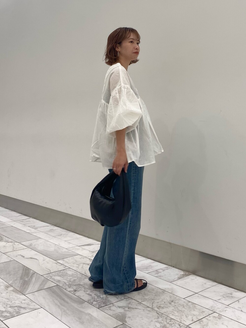ホワイト系のシャツ/ブラウス、ブルー系のデニムパンツを着用したレディースの夏コーディネートの2枚目の写真