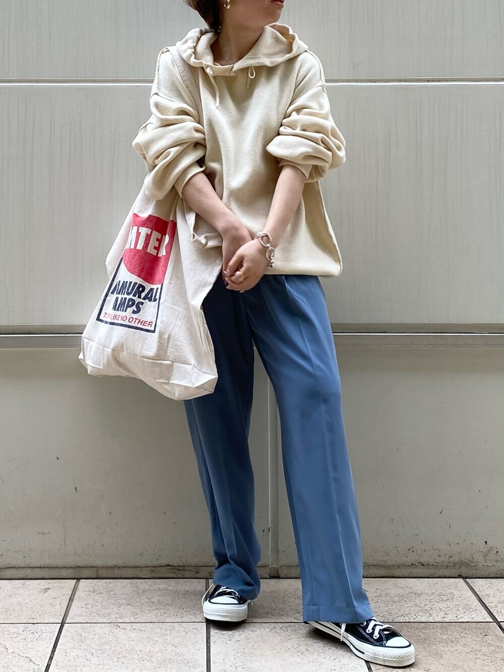 ブルー系のその他パンツ、レッド系のトートバッグ、ホワイト系のニット/セーターを着用したレディースの冬コーディネートの2枚目の写真