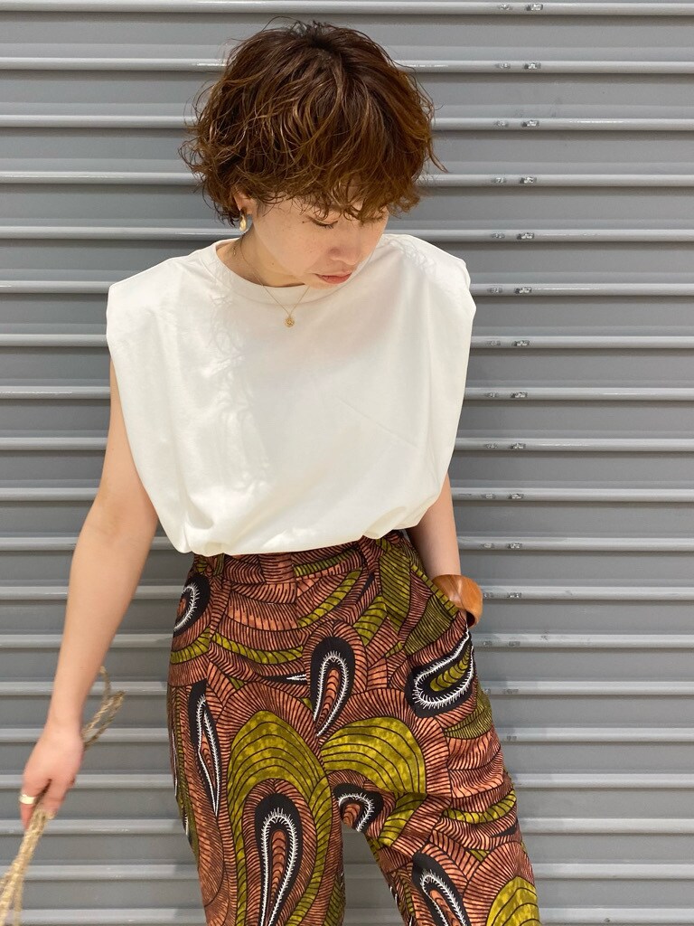 グリーン系のその他パンツ、ベージュ系のかごバッグ、ブラック系のサンダルを着用したレディースの春コーディネートの3枚目の写真