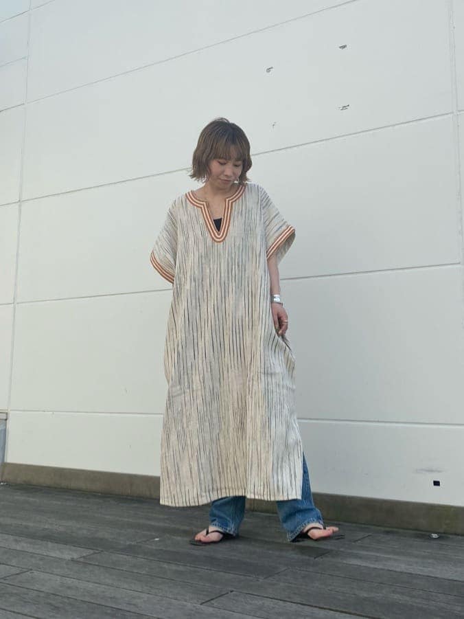 オレンジ系のその他パンツ、オレンジ系のワンピース、ブラック系のハンドバッグを着用したレディースの春コーディネートの6枚目の写真