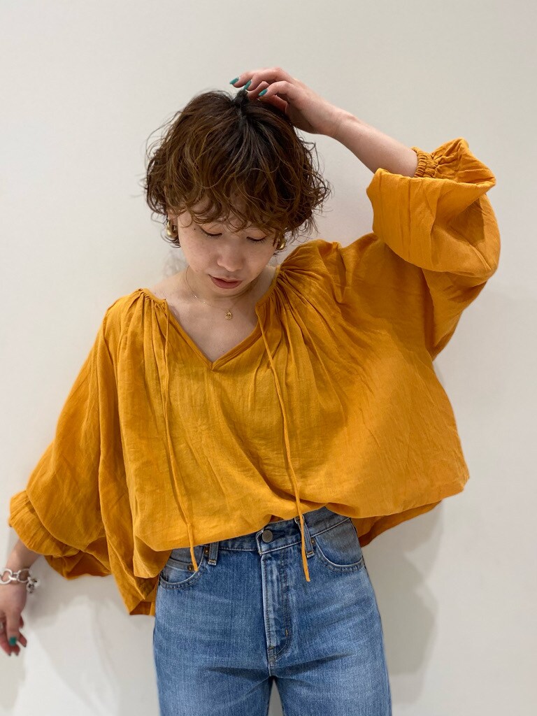 ブルー系のデニムパンツ、オレンジ系のシャツ/ブラウス、ブラック系のサンダルを着用したレディースの春コーディネートの3枚目の写真